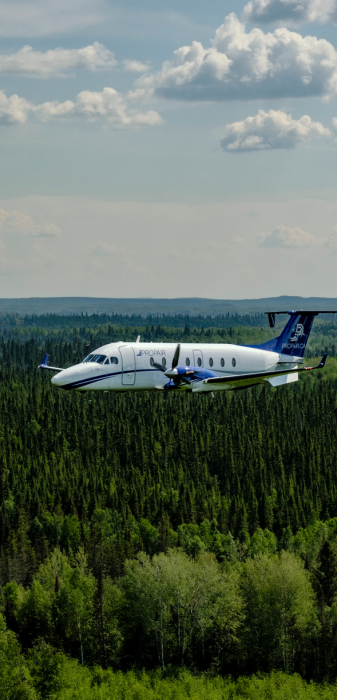 A Propair B1900D aircraft flies over the Boreal Forest.